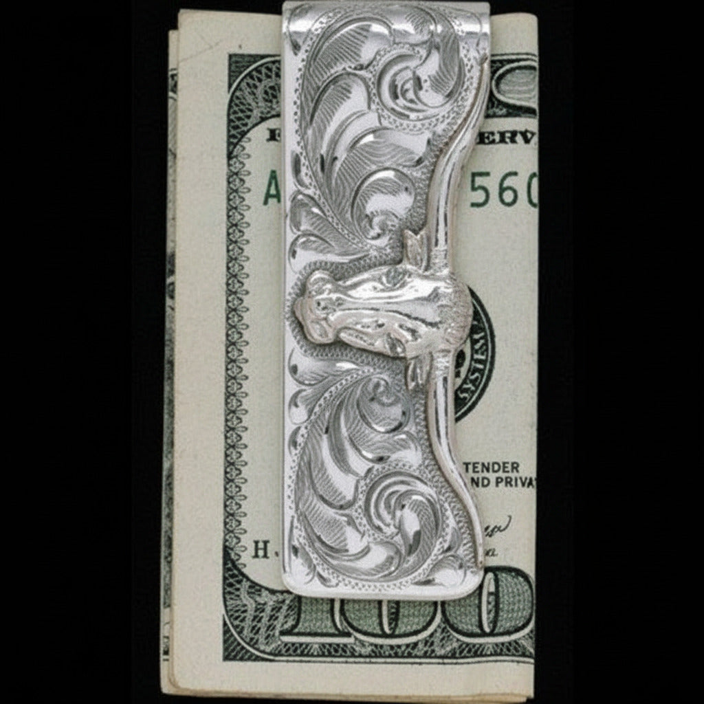 A sterling silver money clip with a hand-engraved three-dimensional longhorn design in gold fill, displayed against a backdrop of folded cash.
